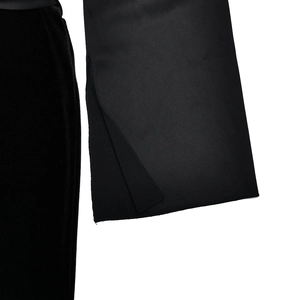 Detailed macro view of black velvet fabric sleeve with split cuff on evening dress