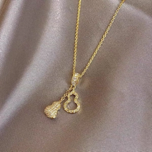 Detailed close-up of double gourd pendant necklace with micro-pave crystals on gold chain