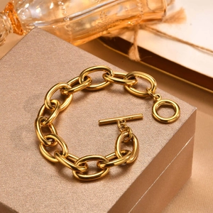 Macro shot of gold-plated thick chain bracelet with OT toggle clasp on gift box