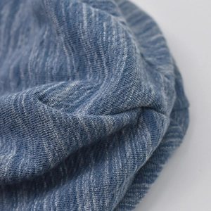 Detailed close-up of the breathable blue melange knit texture of this soft cotton beanie