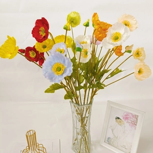 Vibrant faux corn poppy bouquet with colorful silk petals in a textured glass vase
