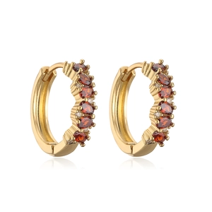 Detailed macro view of 18K gold-plated hoops with red oval gems and clear zircons