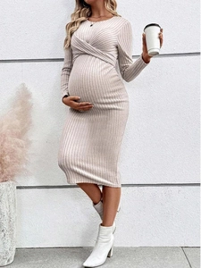 Close-up of beige knit maternity dress showing ribbed texture and front twist knot detail