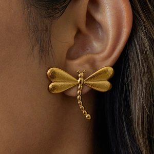 Boucles d'oreilles libellule en acier titane doré avec finition texturée sur mannequin