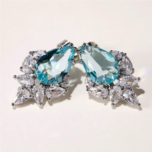 Detailed close-up of water drop light blue gemstone earrings with white zircon clusters