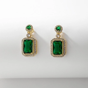 Détail macro de boucles d'oreilles vintage avec cristaux verts carrés et dorure de luxe