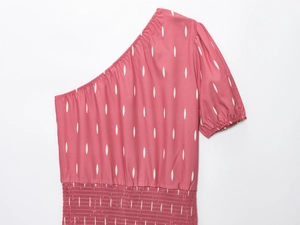 Détail du haut rose à une épaule avec imprimé blanc et taille élastique froncée