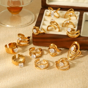 Detailed close-up of a stack of gold rings with cubic zirconia on a warm wooden surface