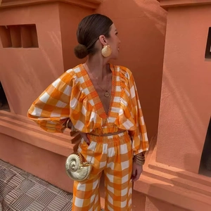 Plaid V-neck puff sleeve crop top and wide-leg trousers set with gold accessories