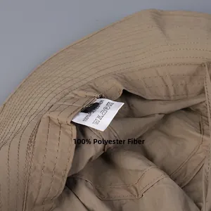Detail view of khaki hiking hat interior showing 100% polyester fabric and washing label