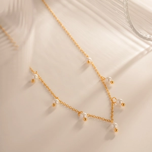 Elegant 18K gold stainless steel necklace with white pearls and tassel accents