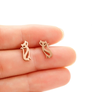 Boucles d'oreilles silhouette chat évidée en or rose montrées pour l'échelle de taille