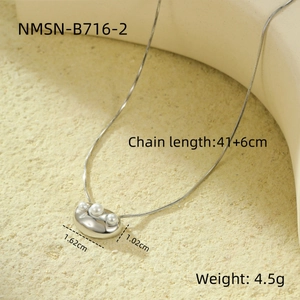 Detail of silver snake chain necklace with a pearl-set irregular metal pendant