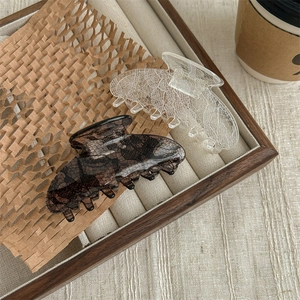Elegant black and white lace pattern hair claws in a vintage wooden jewelry tray