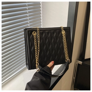 Close-up of black quilted shoulder bag featuring premium texture and gold chain strap