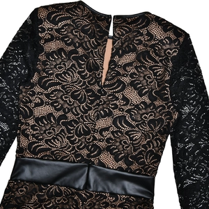 Detail view of lace pattern and faux leather belt on this black bodysuit