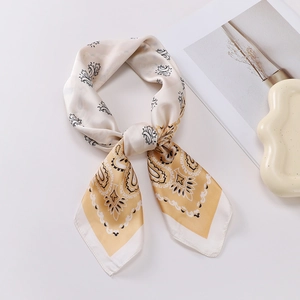 Detail of a beige paisley print faux silk square scarf tied in a decorative knot