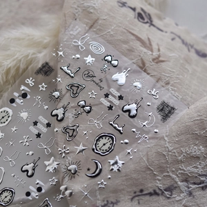 Macro detail of 3D silver chrome nail stickers with star and heart metallic patterns