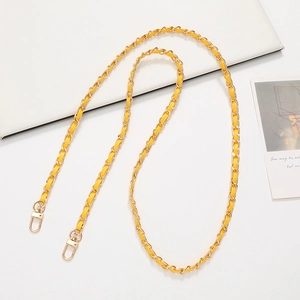 Detail view of woven yellow leather and gold metal chain strap with lobster clasps