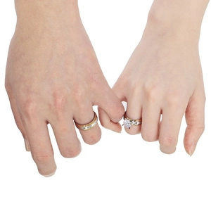 Two-tone stainless steel couple rings set with a round-cut diamond for engagement