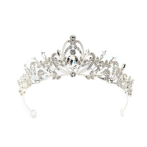 Detailed view of silver bridal crown featuring intricate hollow patterns and clear rhinestones