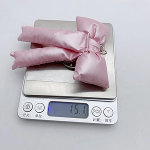 Detailed scale view showing the pink satin bow pendant weighing 15.1 grams