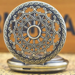 Macro shot of vintage bronze quartz pocket watch with hollow heart and swirl patterns