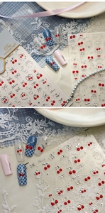 Close-up of 3D embossed cherry and bow nail stickers with red and silver metallic accents