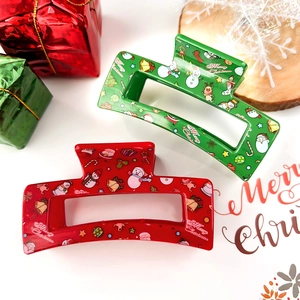 Red and green Christmas hair claws with reindeer print on clean festive background