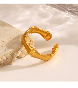 Close-up of golden bamboo joint style adjustable open ring on a stone pedestal