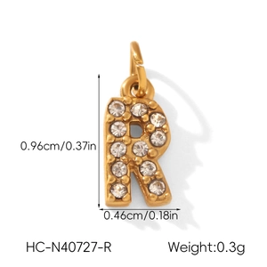 Détail macro du pendentif lettre R doré avec zircons en micro-pavage étincelants