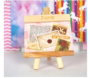 Mini wooden easel holding a vintage aesthetic card with retro collage details