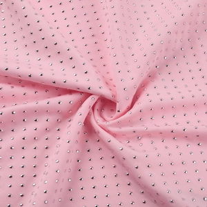 Macro shot of pink sparkling fabric with silver studs showing texture and pleats