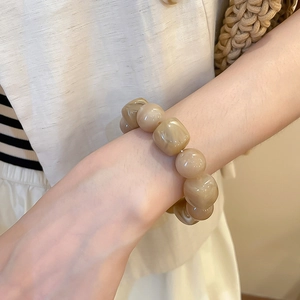 Détail d'un bracelet en perles acryliques texture marbre porté pour un look élégant