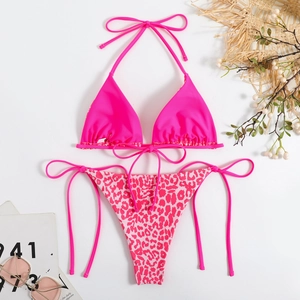 Flat lay of pink bikini set with halter top and leopard print tie-side bottoms for summer