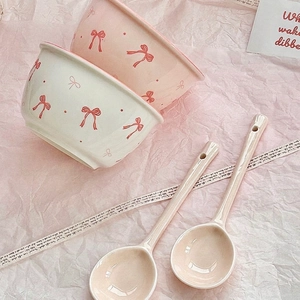 Ceramic bowl and spoon set with hand-painted bow pattern in cream and pink