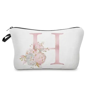 Close-up detail of a white makeup bag featuring a pink floral letter H printed design