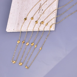 Detailed shot of three minimalist gold necklaces with floral, square and oval pendants