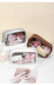 Close-up of three waterproof PU leather toiletry bags with clear windows in warm tones