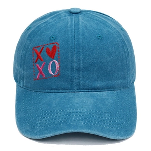 Dettaglio del ricamo XOXO e cuore rosso su cappello da baseball blu lavato vintage