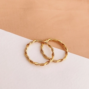 Detailed macro shot of twisted rope gold rings with elegant metallic braided texture