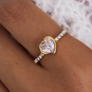 Vista macro di un anello in acciaio placcato oro 18K con zircone a cuore e cristalli