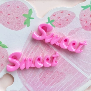 Détail de breloques Sweet en résine rose pour bricolage sur fond de fraises