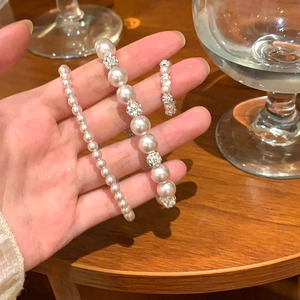 Gros plan d'un ensemble de bracelets en perles élégantes avec diamants et bague assortie