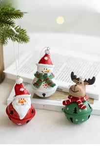 Close-up of metal Christmas bells featuring Santa, Snowman and Reindeer with star cutouts