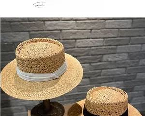 Details von Strohhüten mit eleganten schwarzen und weißen Bandschleifen auf Texturhintergrund