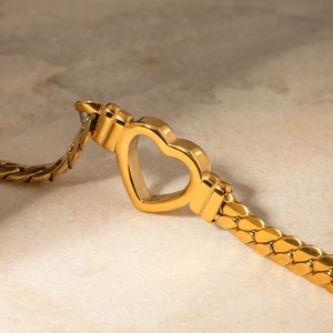 14K gold plated stainless steel flat snake chain bracelet with heart charm on marble