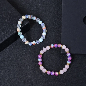 8mm Emperor Stone and Rose Quartz beaded stretch bracelets set on a black textured background