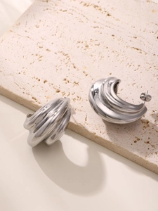 Detailed view of silver multi-layered curved earrings with polished mirror finish