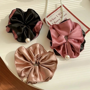 Three-piece set of satin scrunchies with pearls in black, pink, and brown silk-like fabric